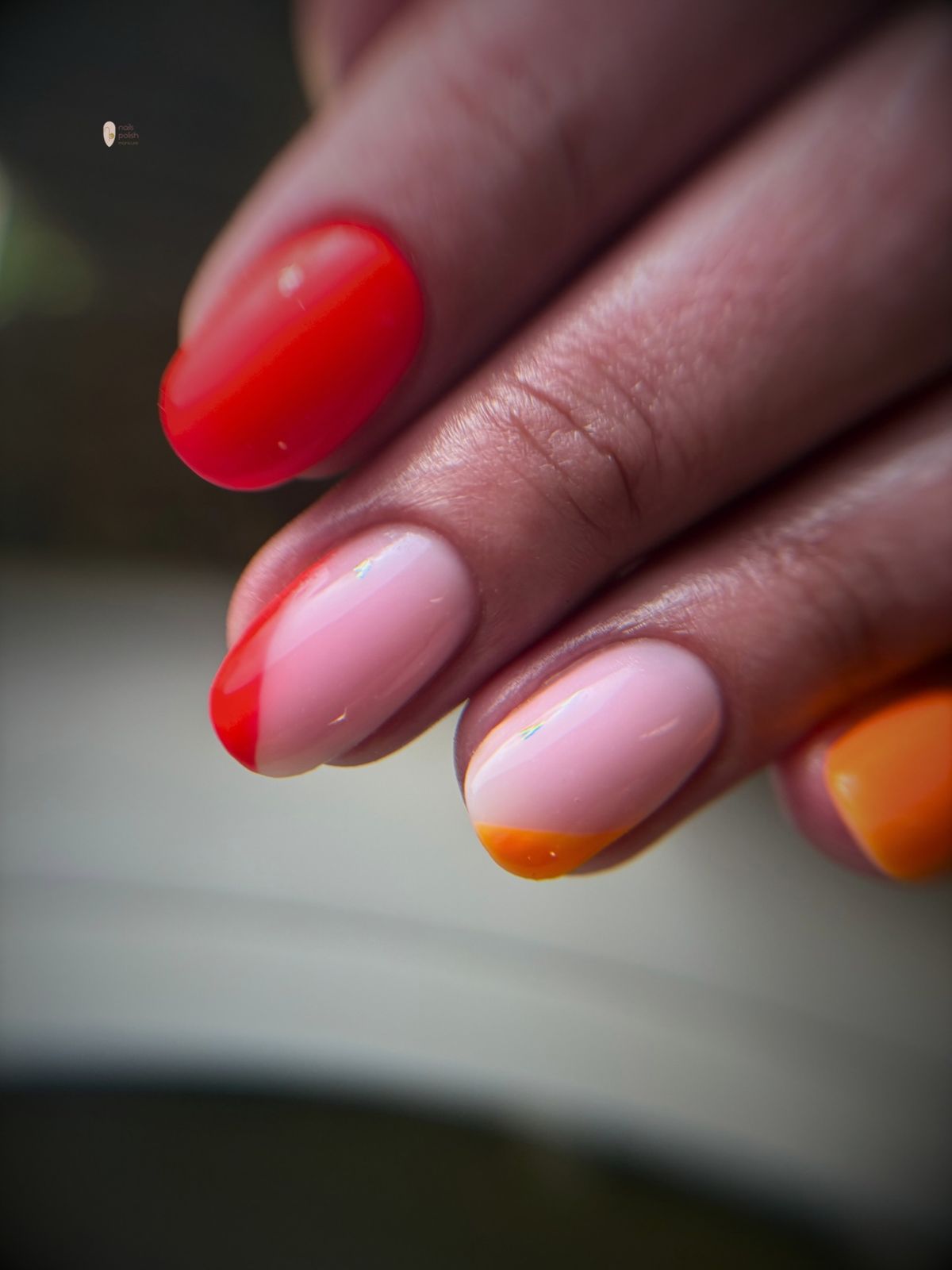 Roze nagels met een rode en oranje french, van dichtbij