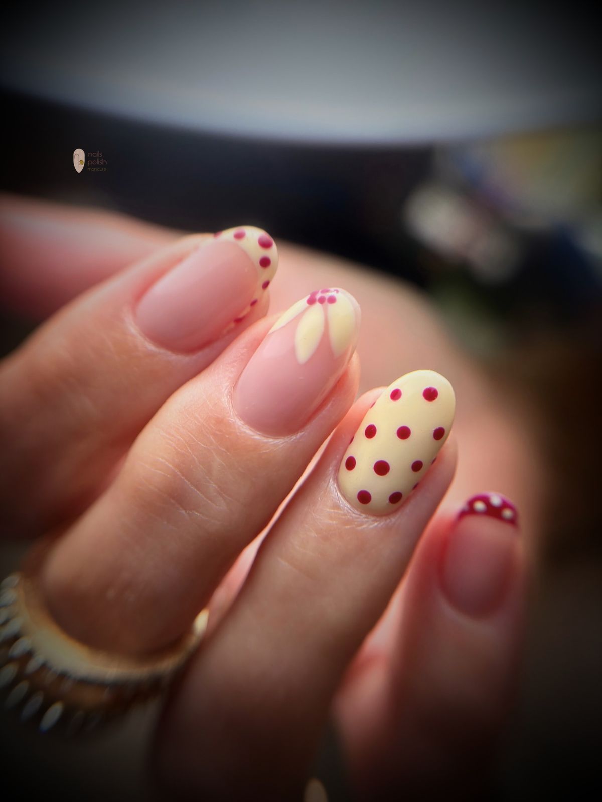 Nagels met botergele en bordeauxrode stippen en een bloemetje