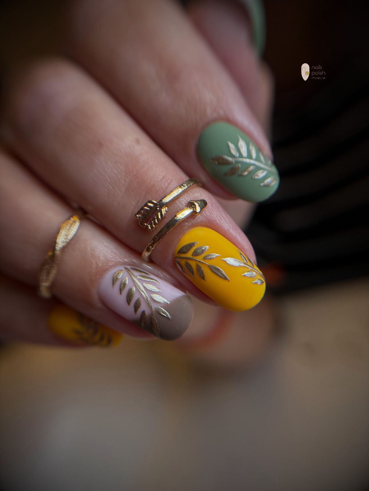 Saliegroene en mosterdgele nagels met gouden blaadjes