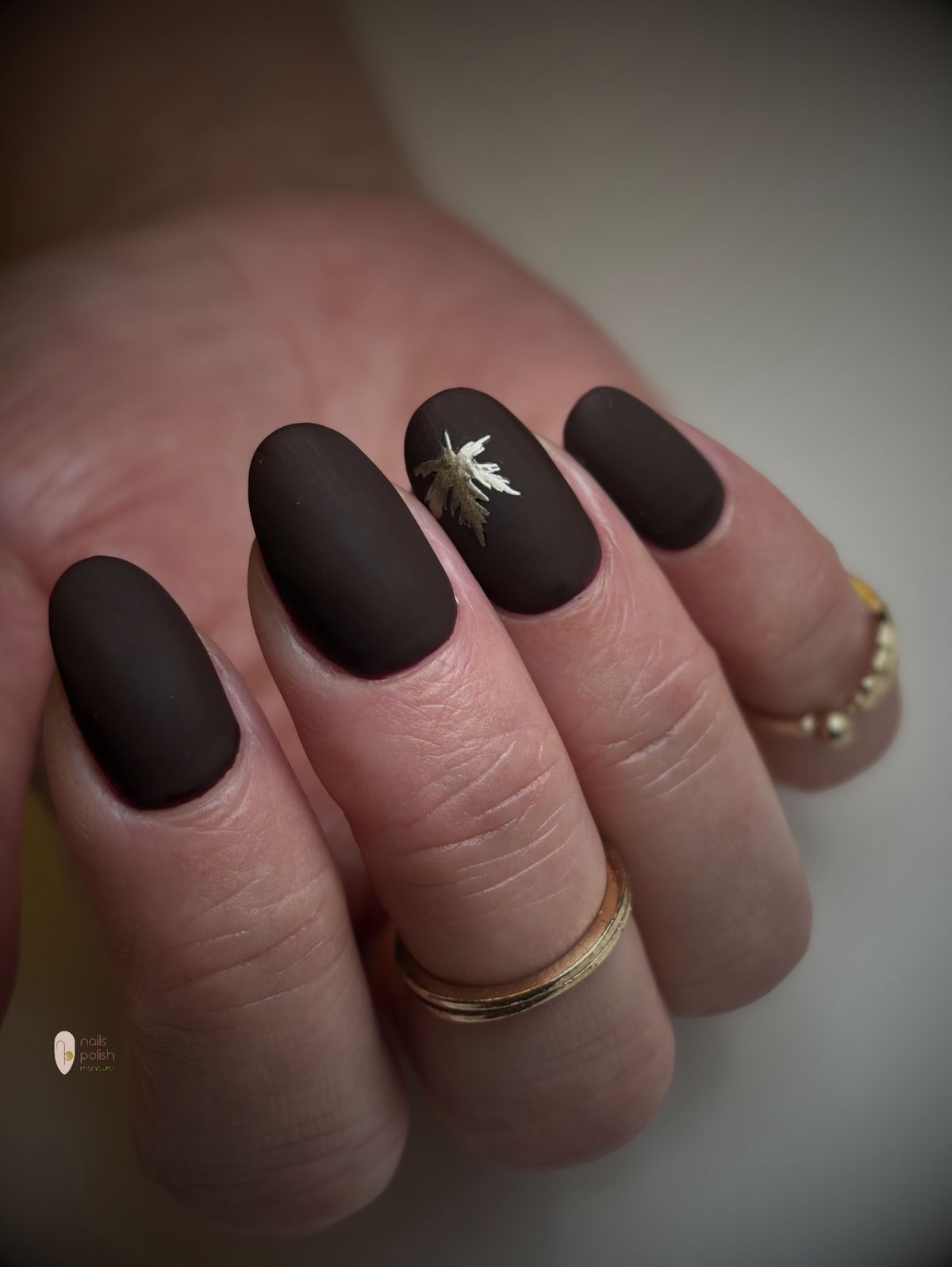 Matte chocoladebruine nagels met een gouden blaadje